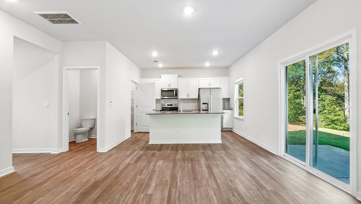 Kitchen and island with white cabinets and wood flooring