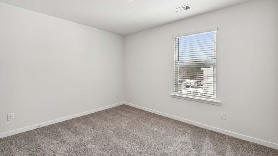 carpeted bedroom with windows