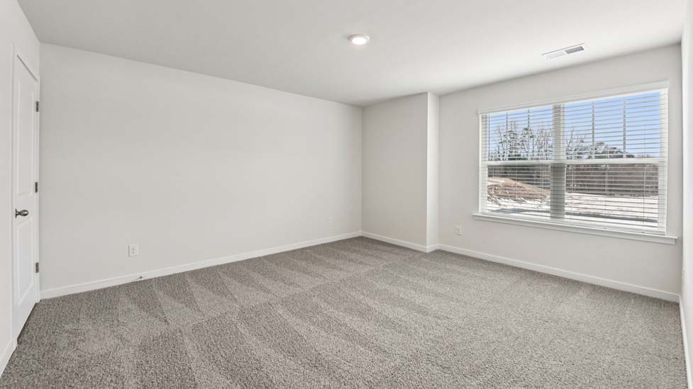 Primary carpeted bedroom with windows