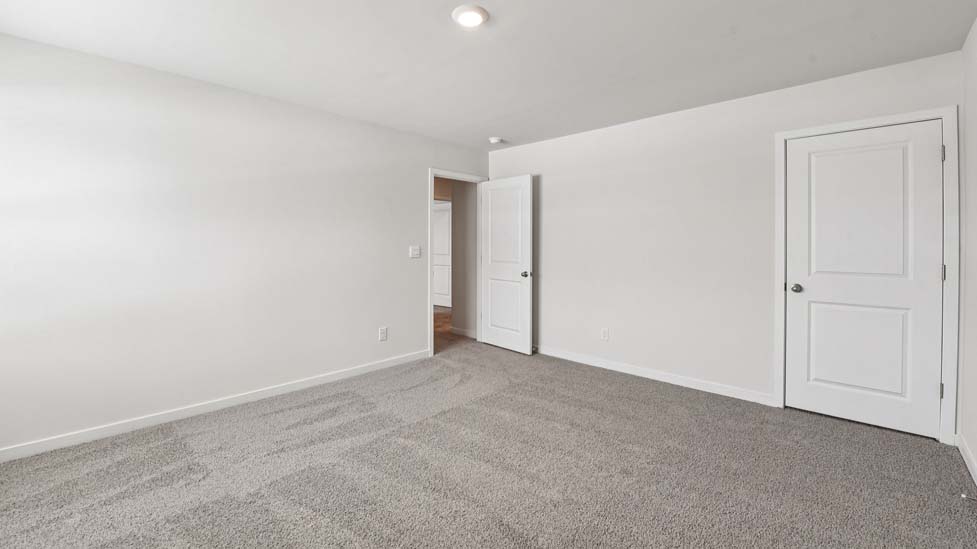 Primary carpeted bedroom with windows