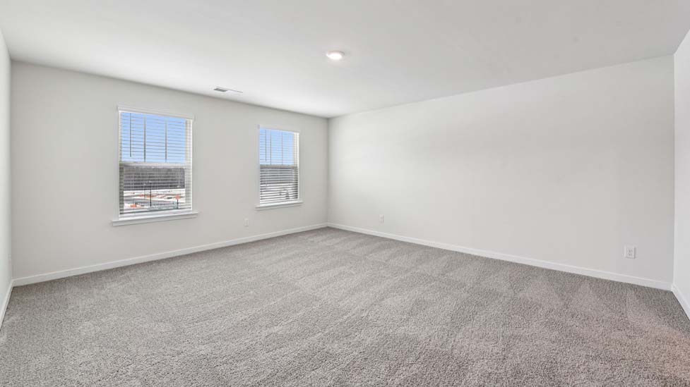 Primary carpeted bedroom with windows