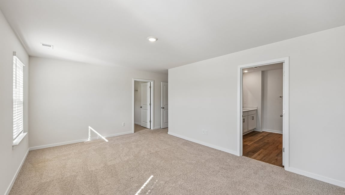 Primary bedroom, carpeted with two large windows