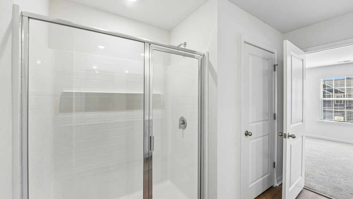 Primary bathroom with double sinks, white cabinets and counters