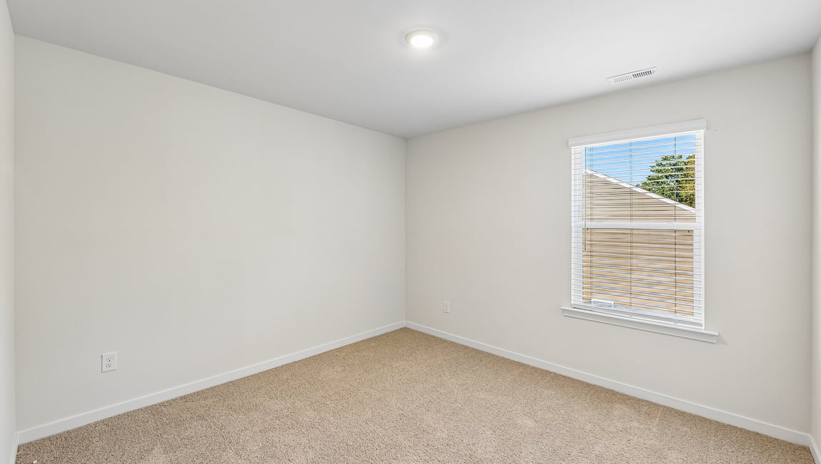 Carpeted bedroom with large window