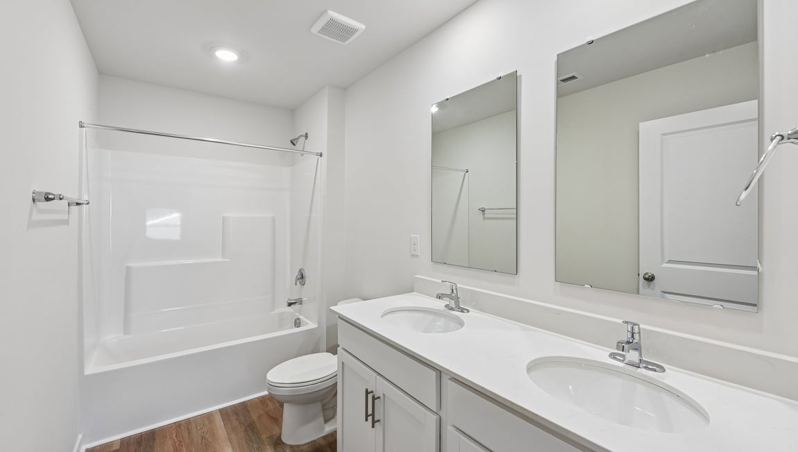 Bathroom with standing shower, white counter and cabinets