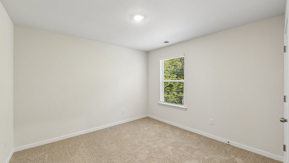 Carpeted bedroom with large window
