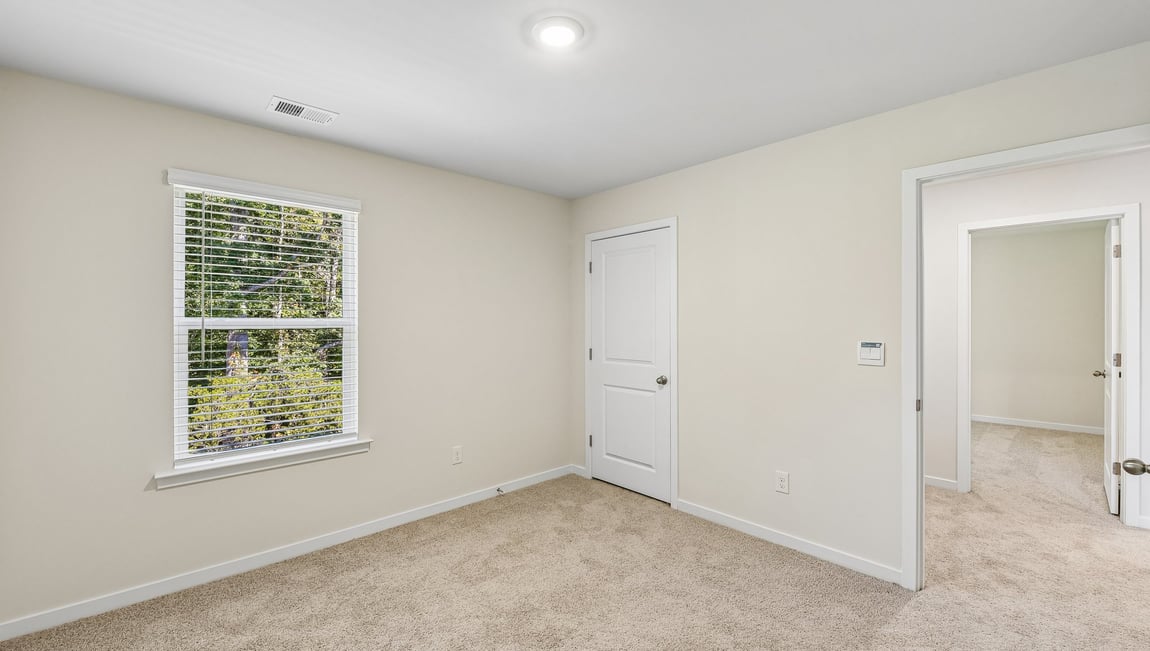 Carpeted bedroom with large window