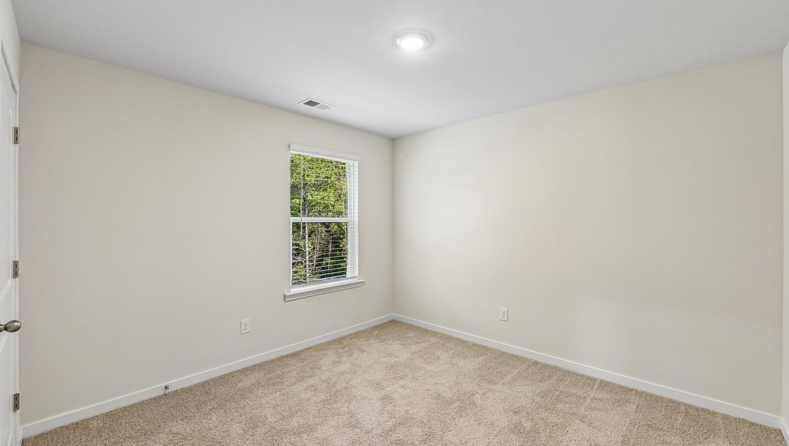 Carpeted bedroom with large window