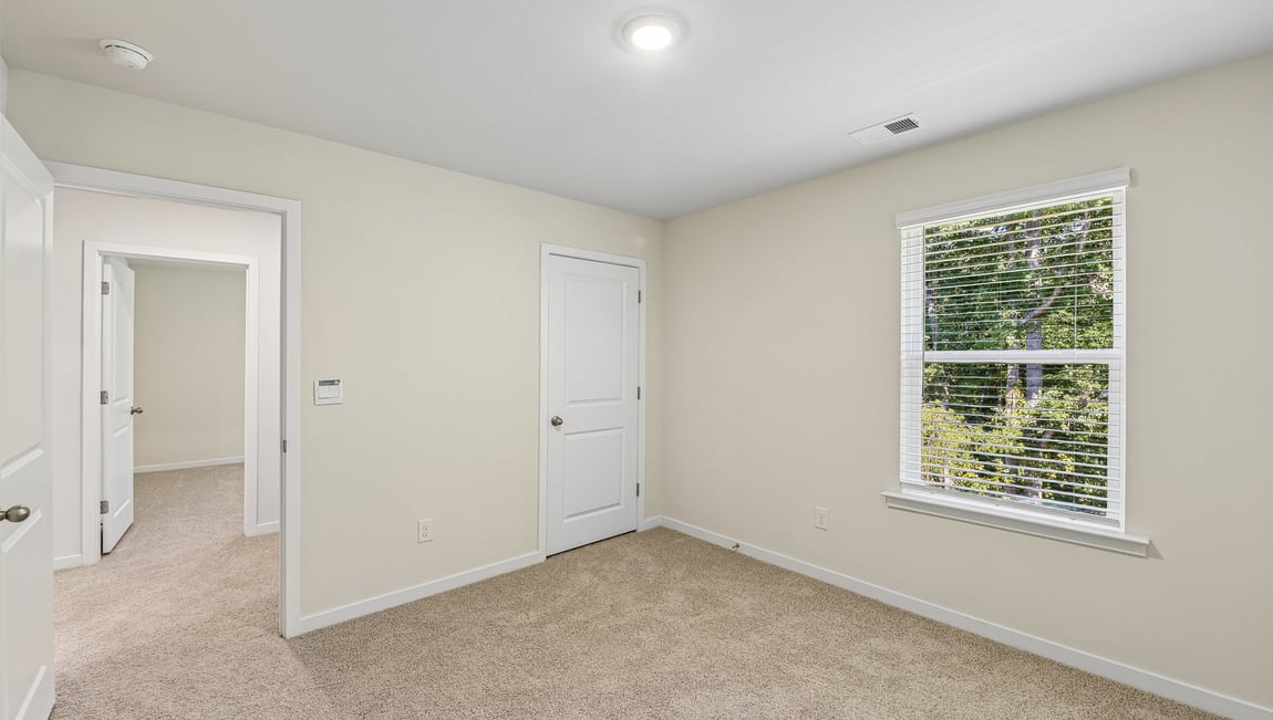 Carpeted bedroom with large window