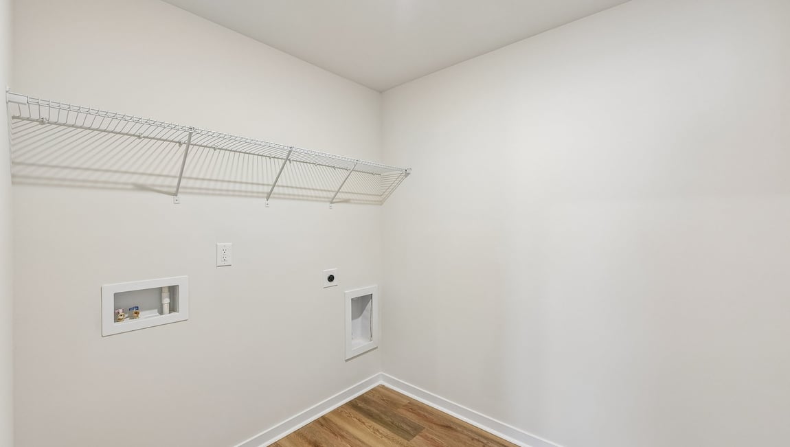 Laundry room with storage hanging racks above machines
