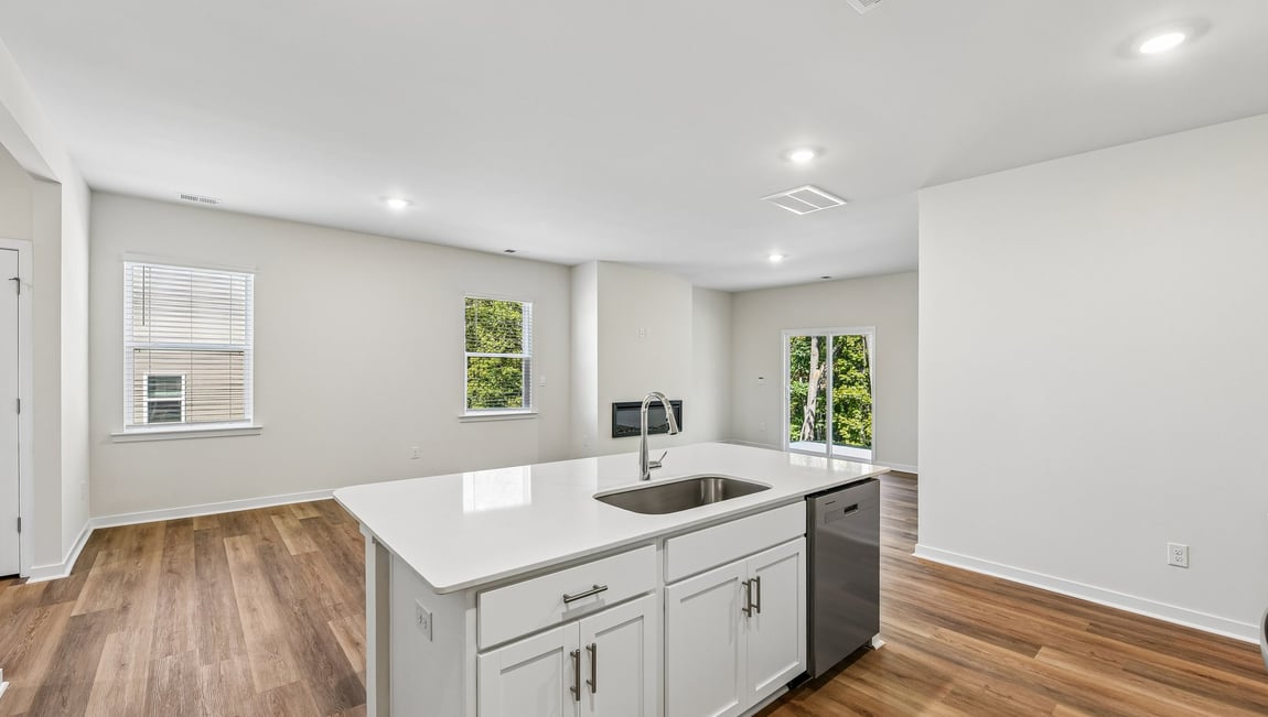 Kitchen and island with white cabinets and wood flooring
