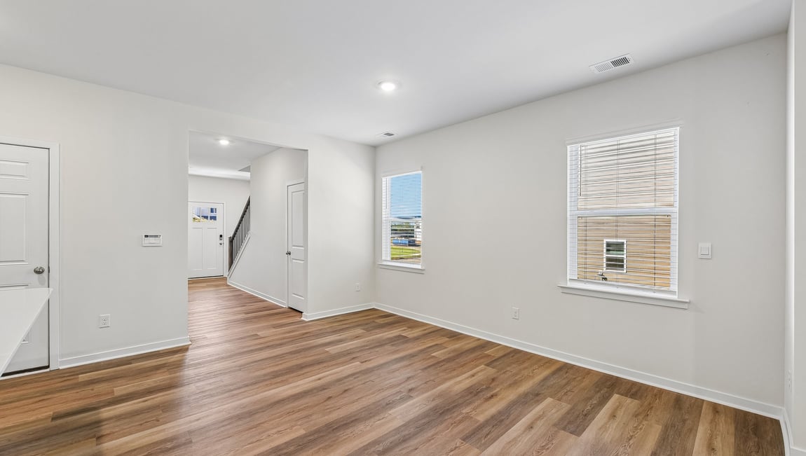 Kitchen and island with white cabinets and wood flooring