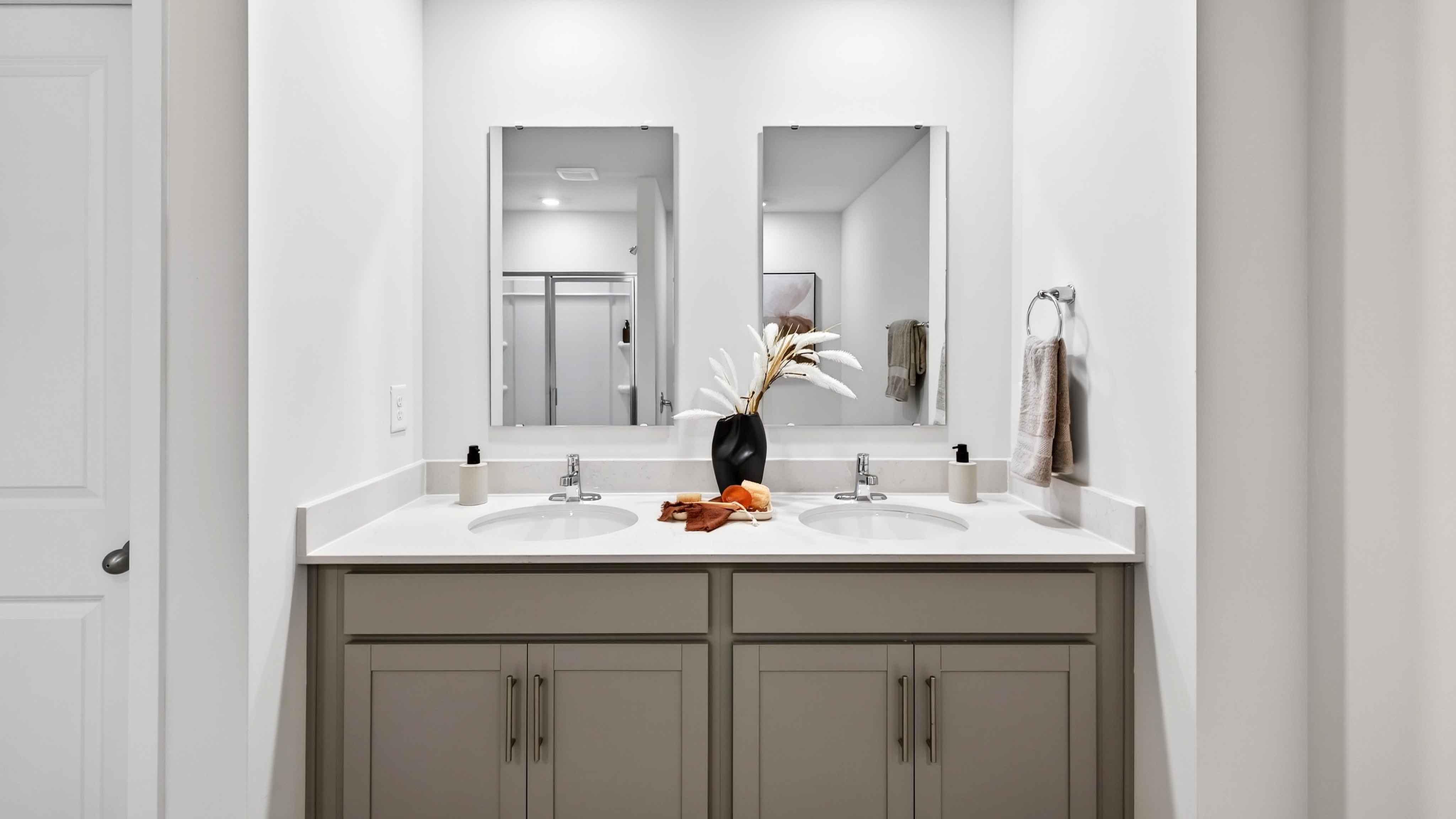 Primary bathroom with double sinks, white cabinets and counters
