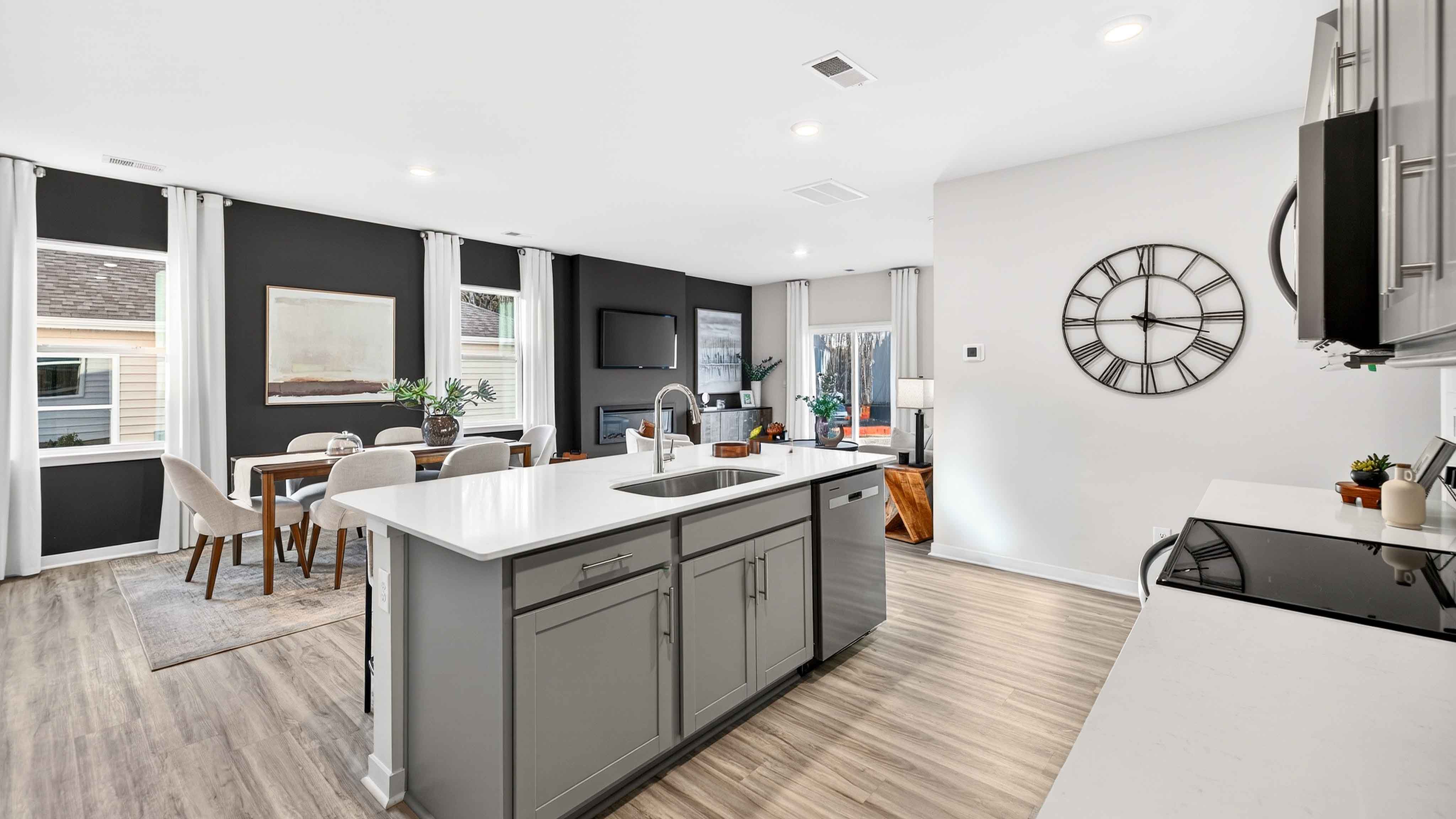 Kitchen and island with white cabinets and wood flooring