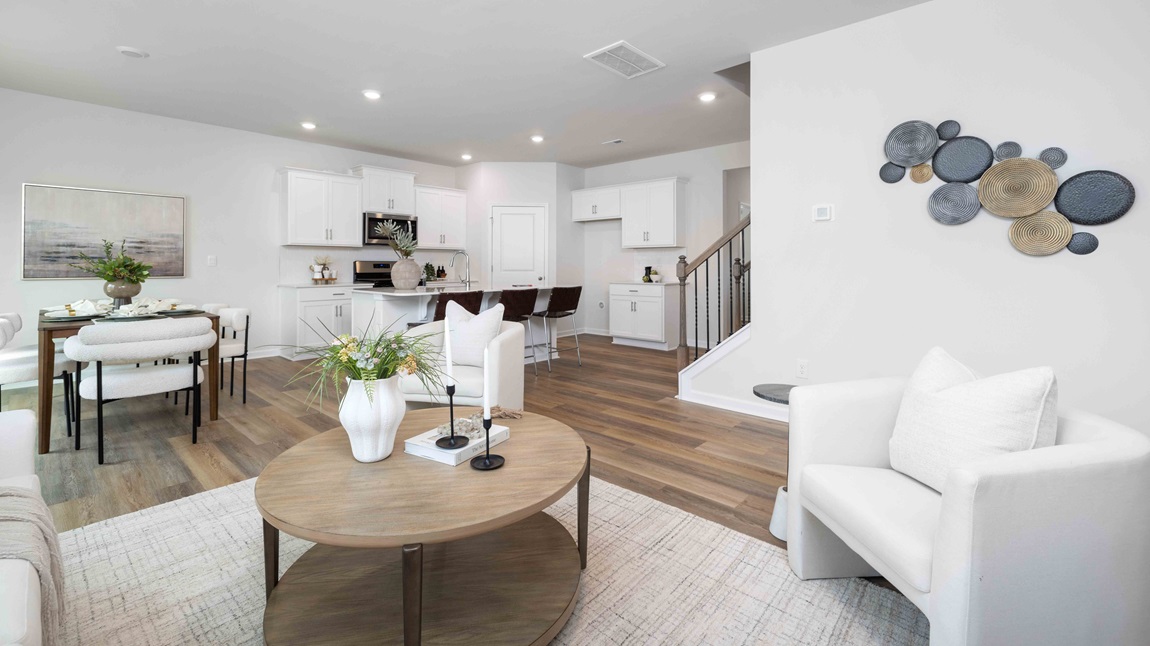 Living room beside kitchen with large window, and electric fireplace