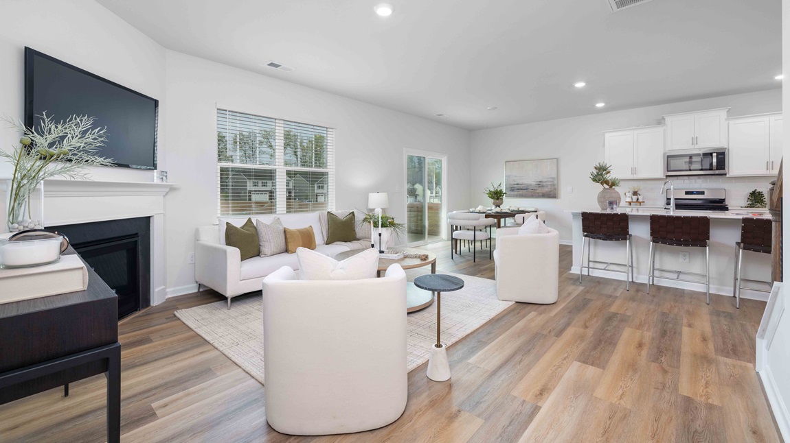 Living room beside kitchen with large window, and electric fireplace