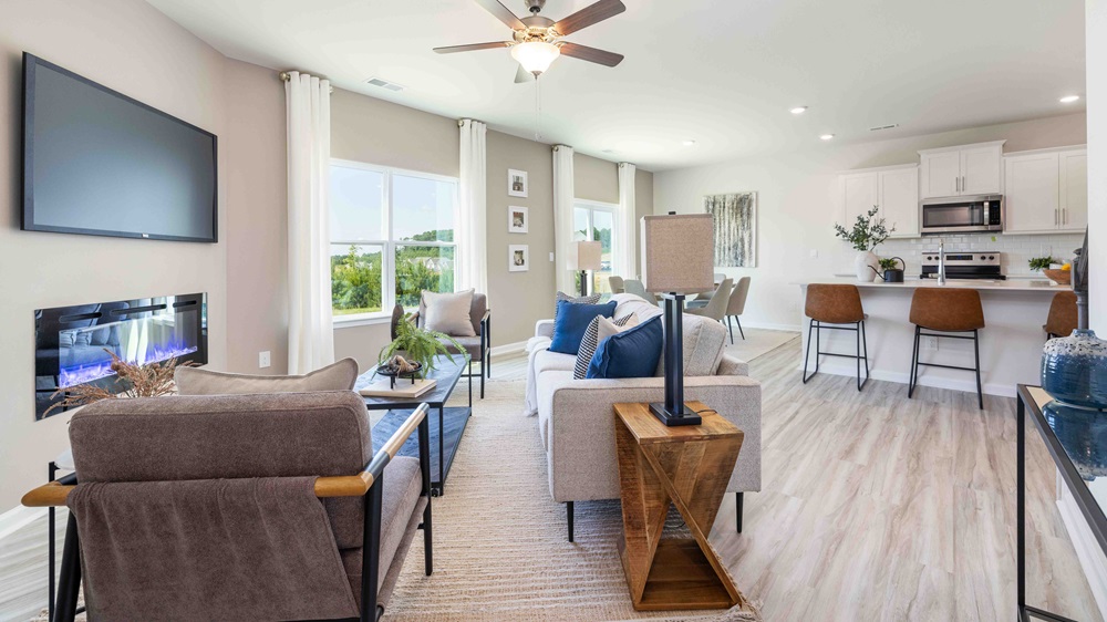 Living room beside kitchen with large window, and electric fireplace