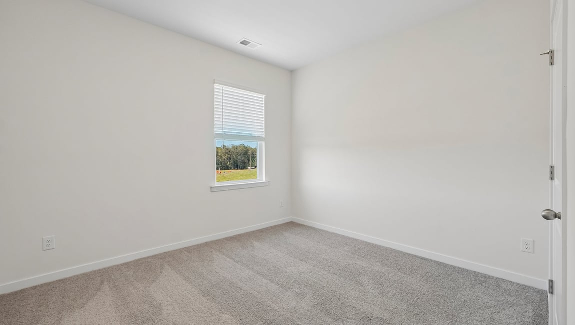 Carpeted bedroom with windows