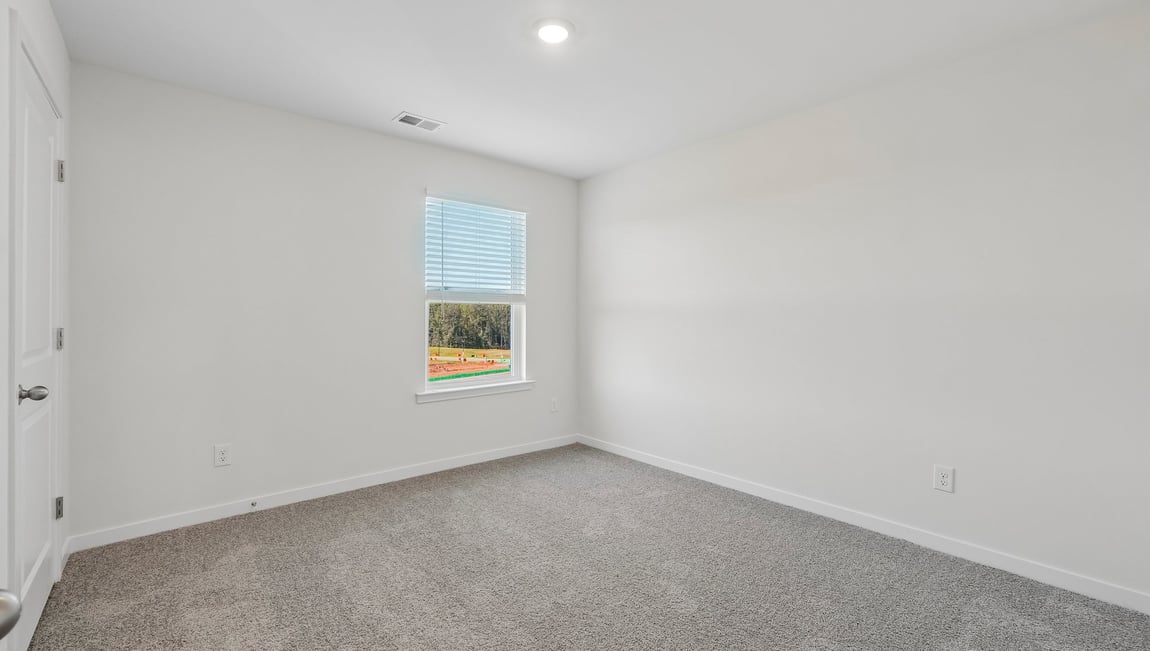Carpeted bedroom with windows