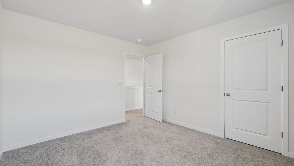 Carpeted bedroom with windows
