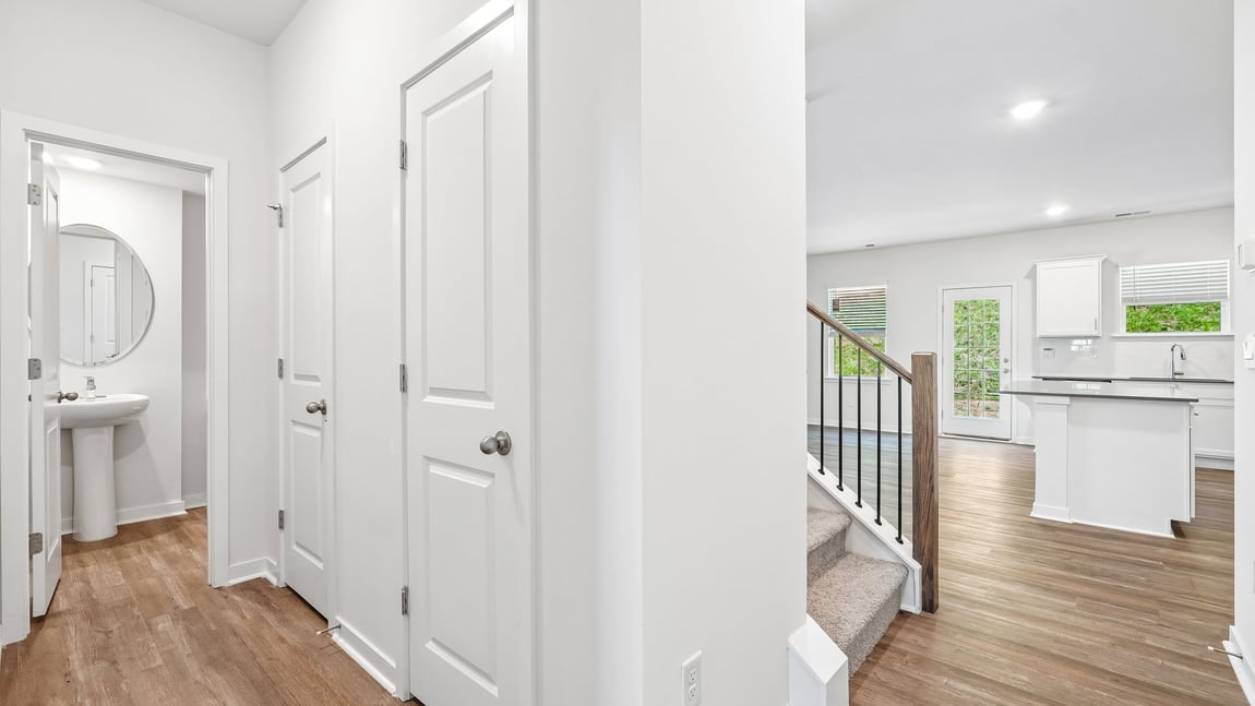 Kitchen and island with white cabinets and wood flooring