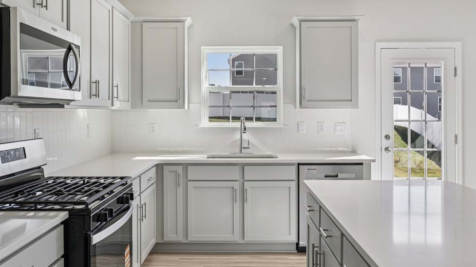 Kitchen and island with white counters and cabinets