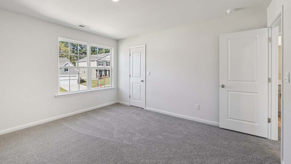 carpeted bedroom with two windows