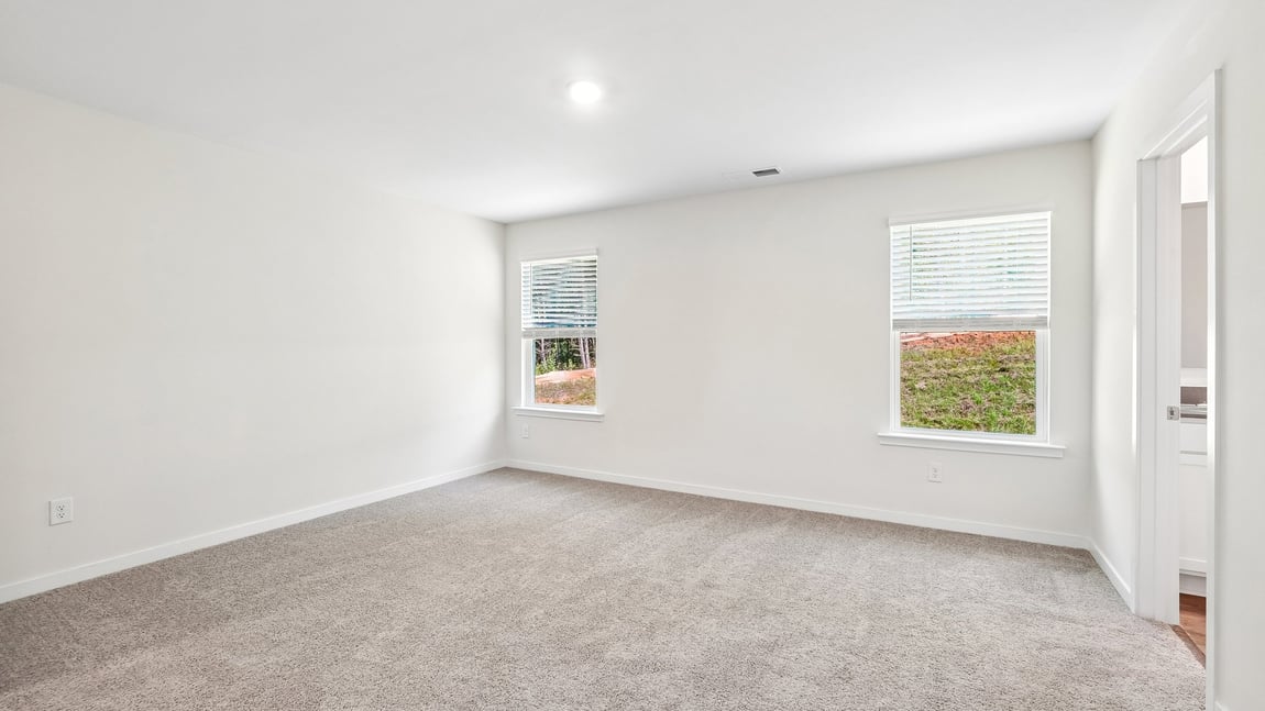 Carpeted bedroom with windows