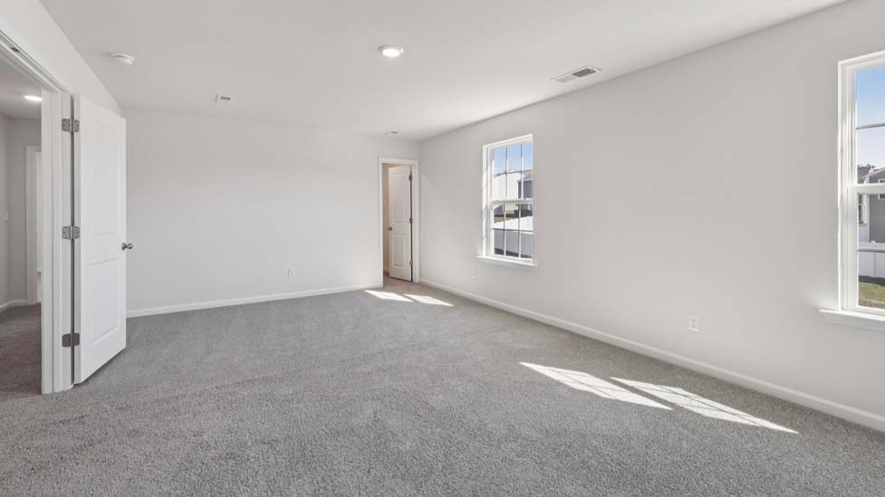 Carpeted loft space atop stairs with large window