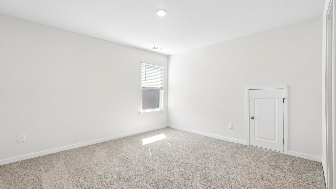 Carpeted bedroom with windows