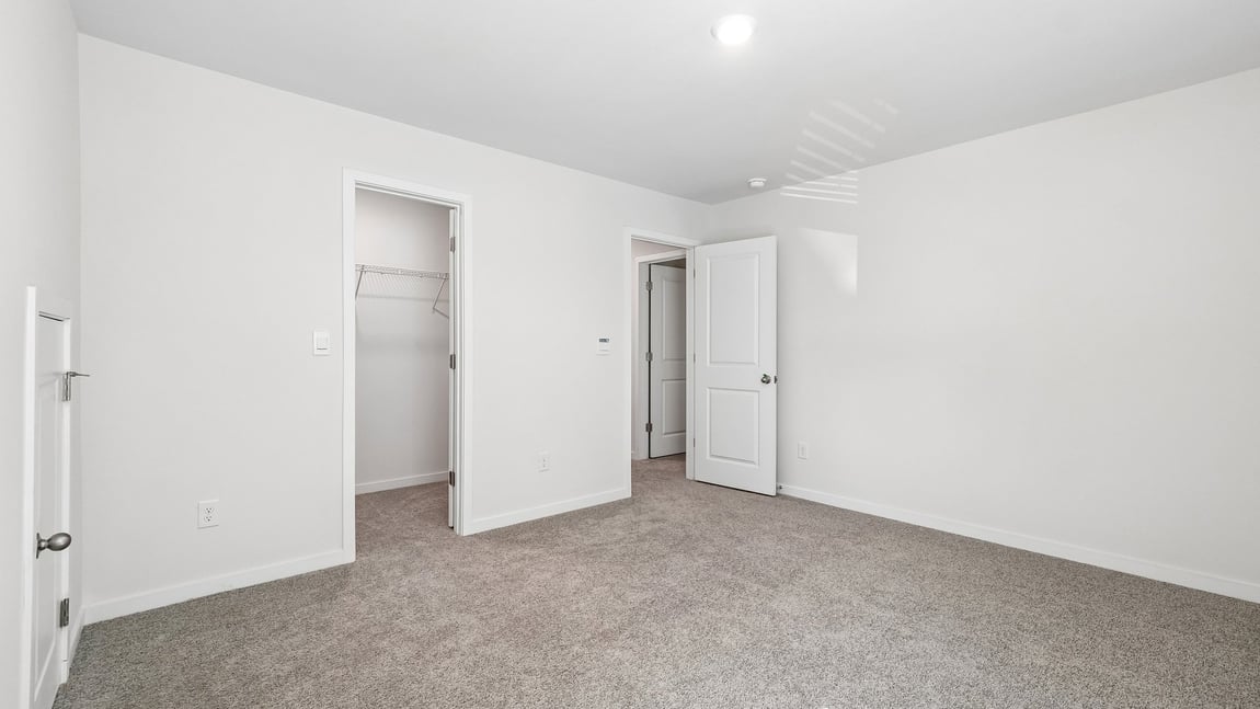 Carpeted bedroom with windows