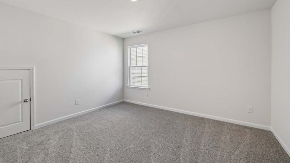 Carpeted bedroom with small window