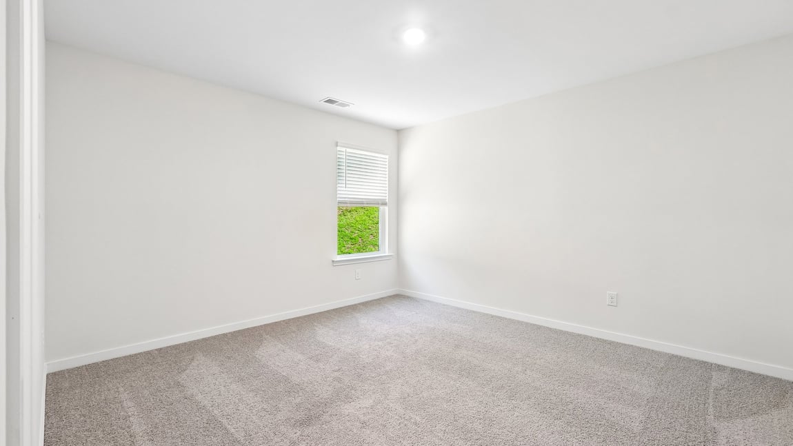 Carpeted bedroom with windows