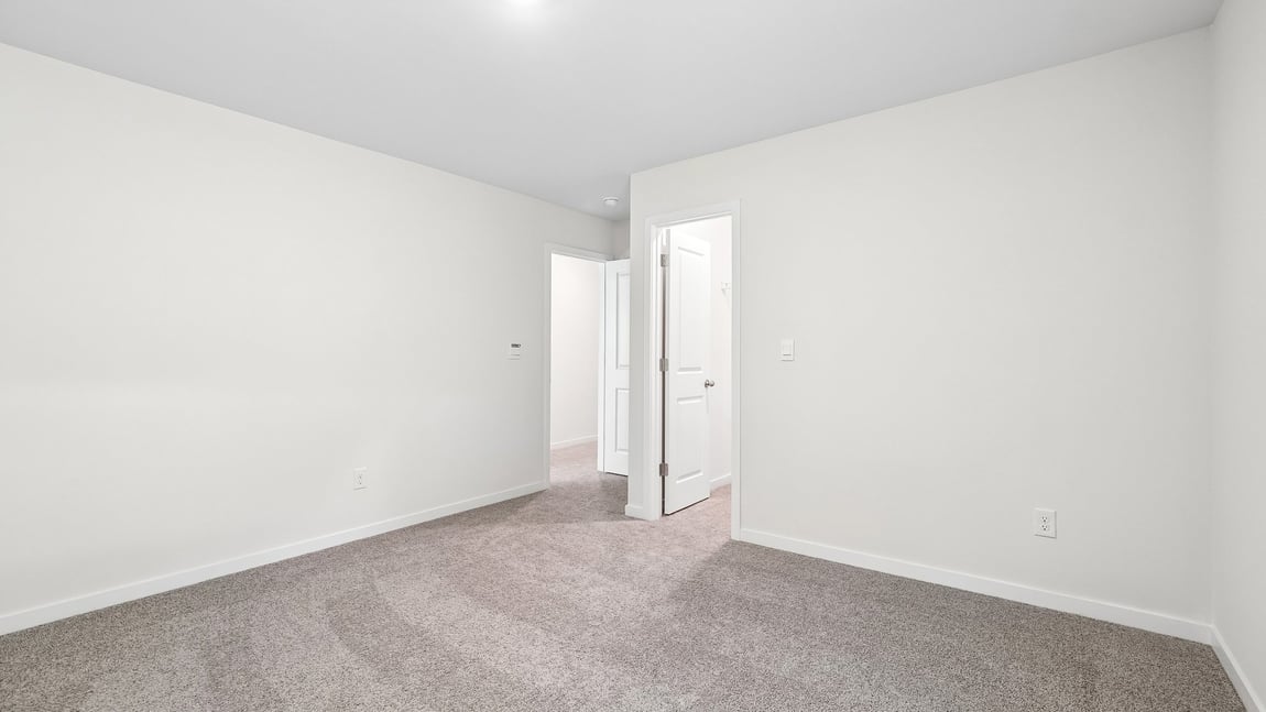 Carpeted bedroom with windows