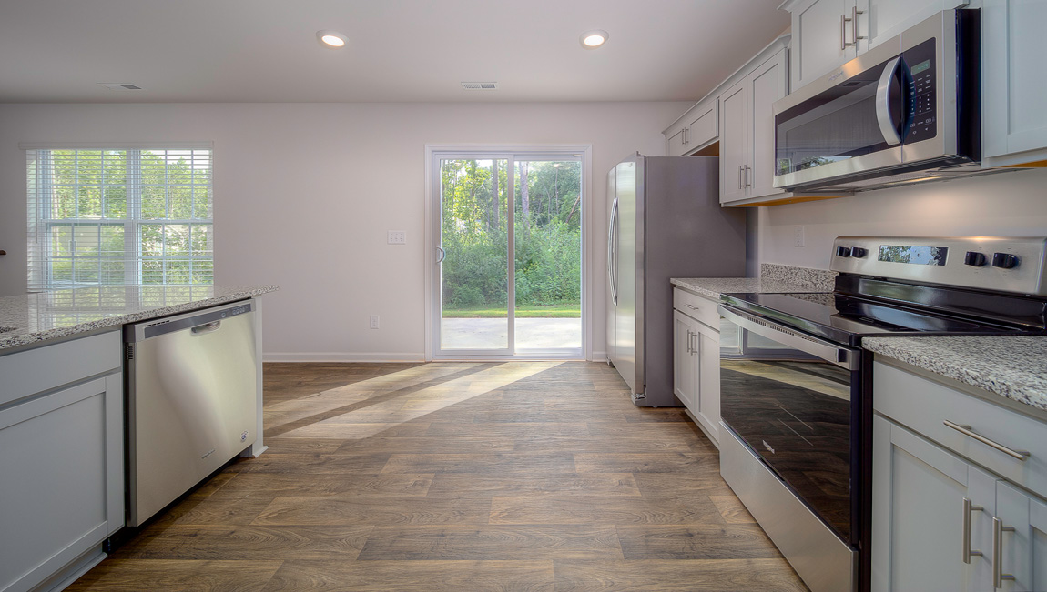 Kitchen with vinyl floors, granite counters, grey cabinets and stainless steel appliances