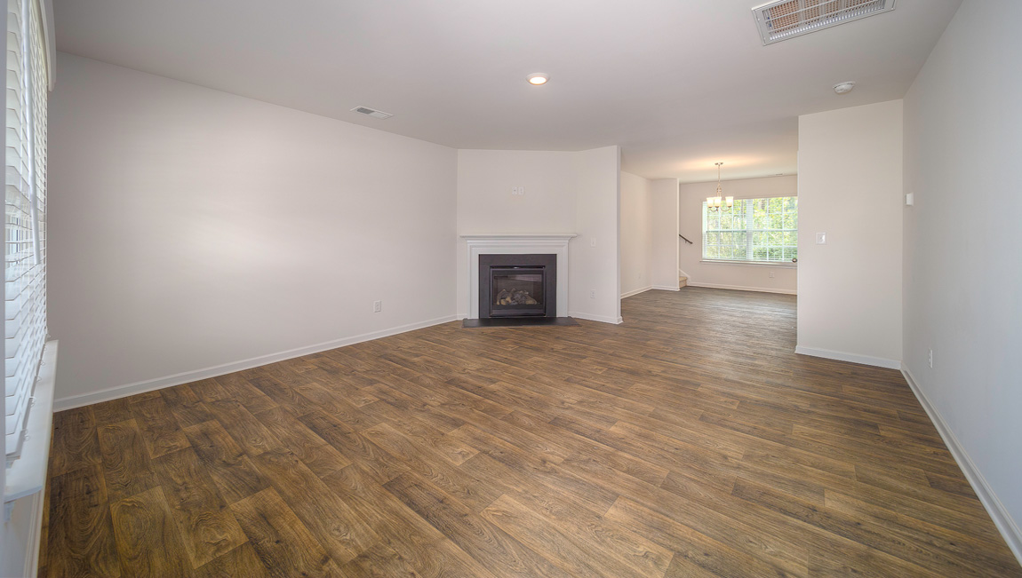 Family room with vinyl floors, large window, and fireplace