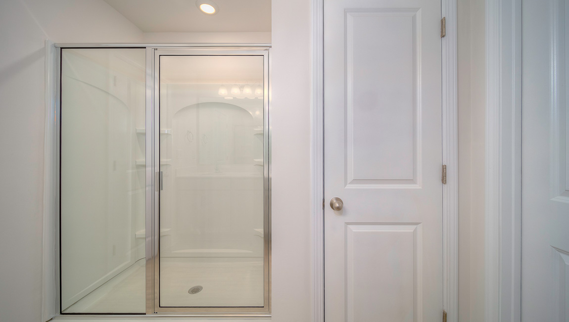 Primary bathroom with double sink vanity, and glass door shower