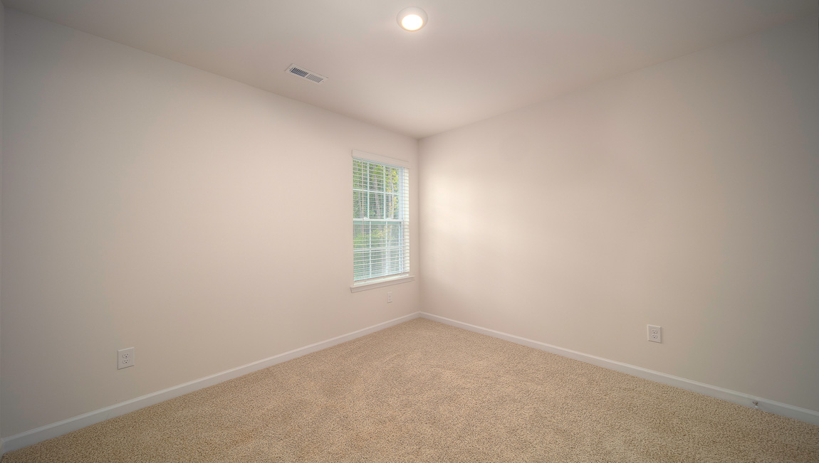 Carpeted bedroom with small window