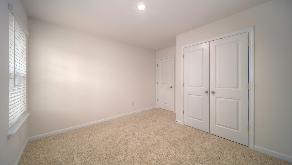 Carpeted bedroom with small window