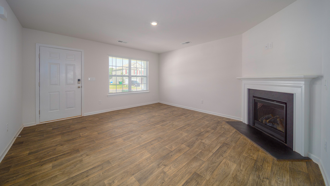 Family room with vinyl floors, large window, and fireplace