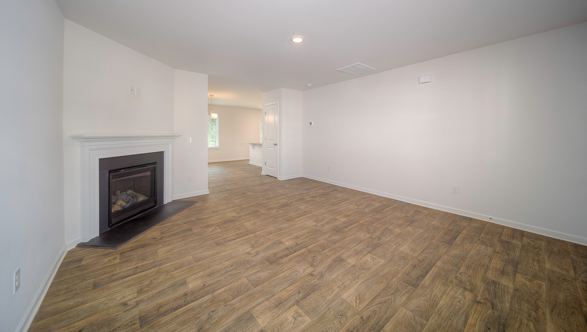 Family room with vinyl floors, large window, and fireplace