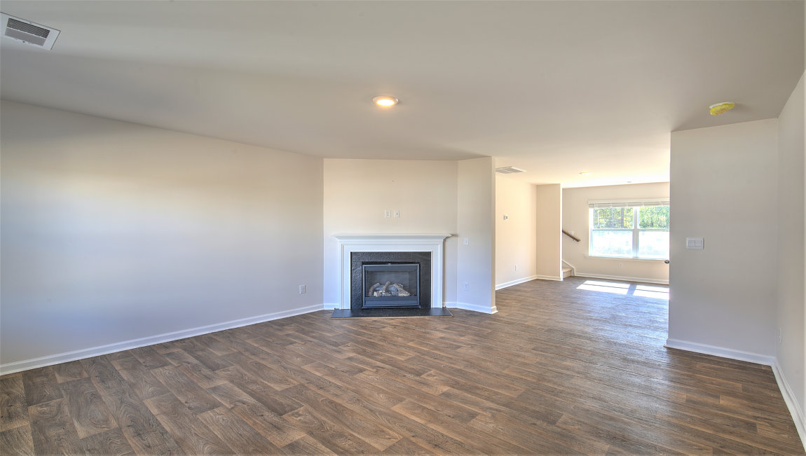 Family room with vinyl floors, large window, and fireplace