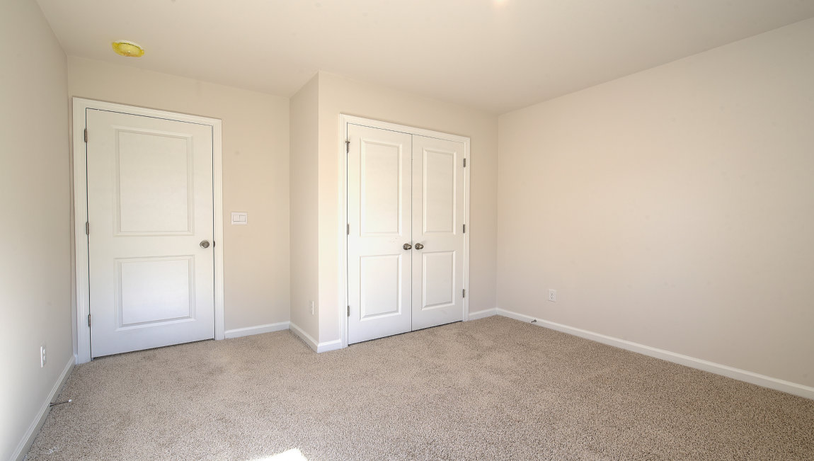 Carpeted bedroom with small window