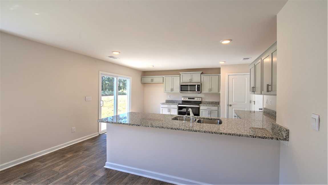Kitchen with vinyl floors, granite counters, grey cabinets and stainless steel appliances