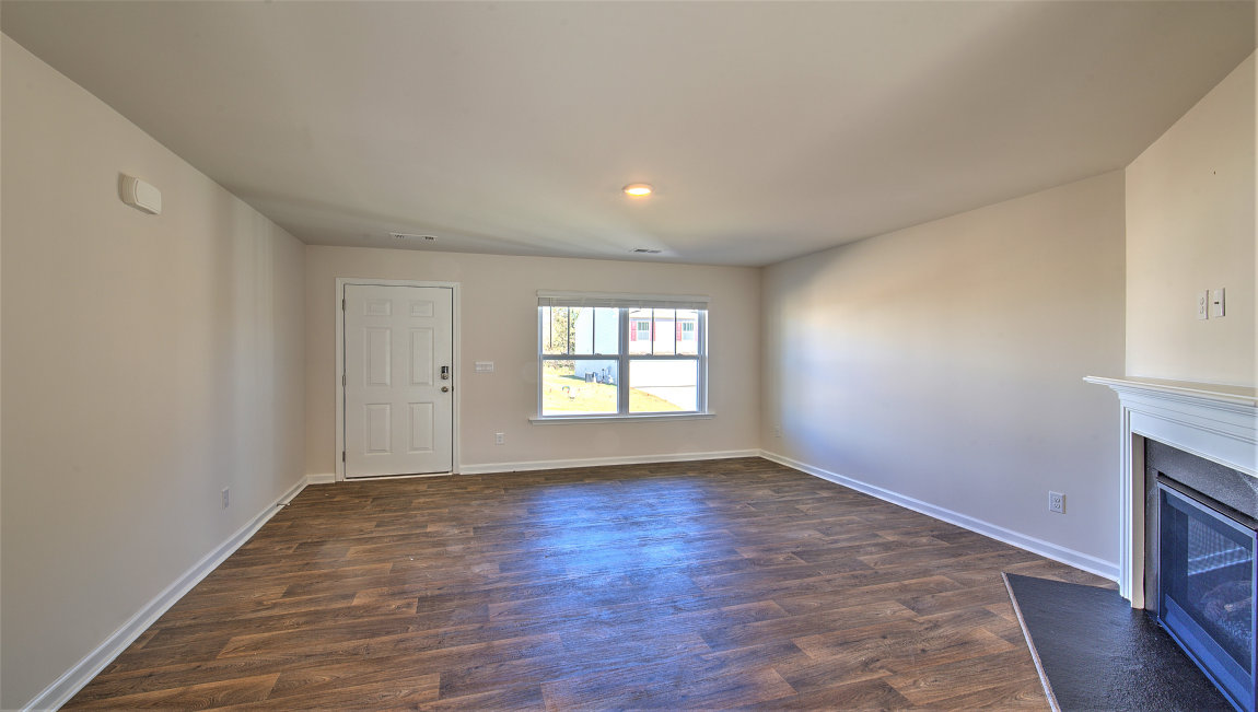 Family room with vinyl floors, large window, and fireplace