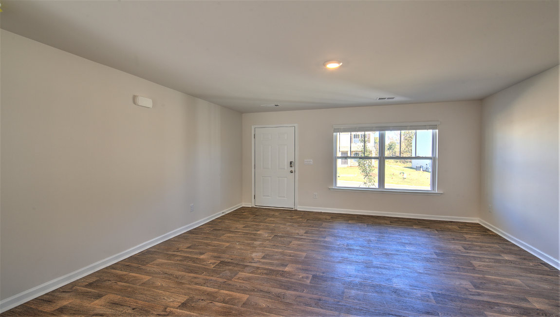 Family room with vinyl floors, large window, and fireplace