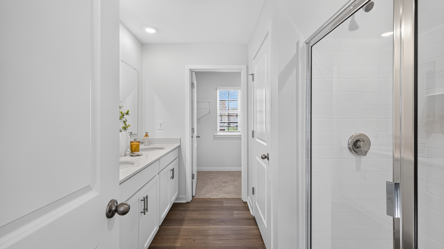 Primary bathroom with standing glass shower and double sinks
