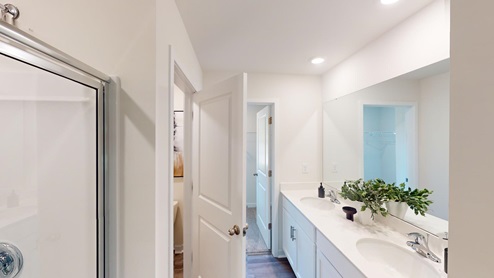 Primary bathroom with double sink vanity, and large standing glass door shower