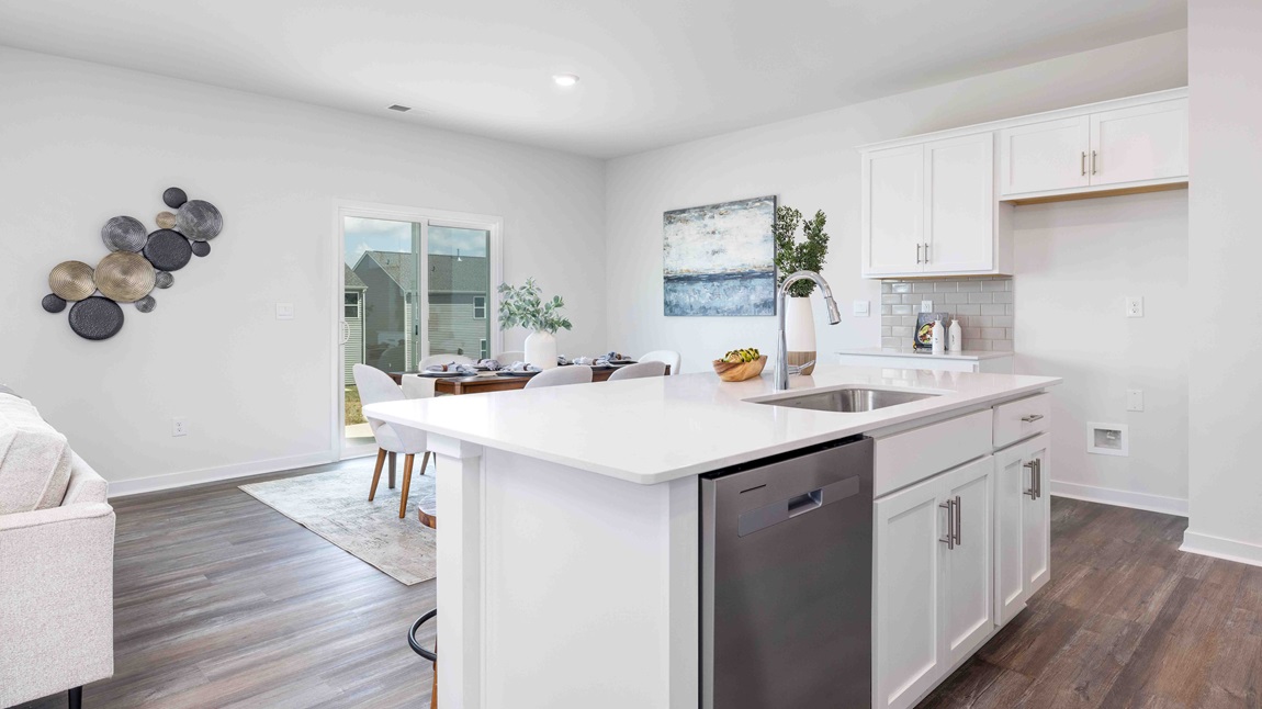 Kitchen and island, white cabinets, wood floors, and stainless steel appliances