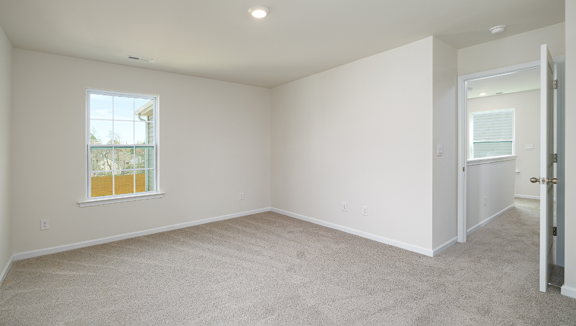 Primary bedroom, carpeted with large windows